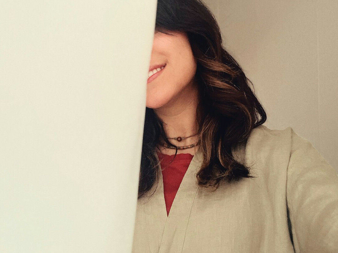 Portrait of a smiling woman with dark hair in a bright office