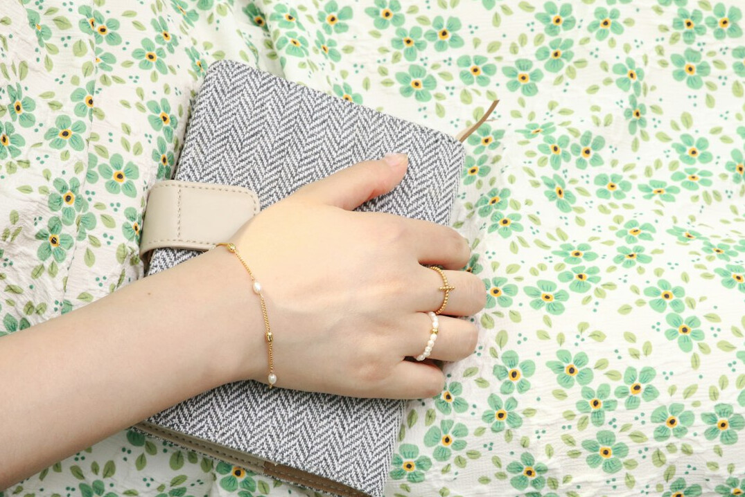 Hand writing in an open notebook on a white desk